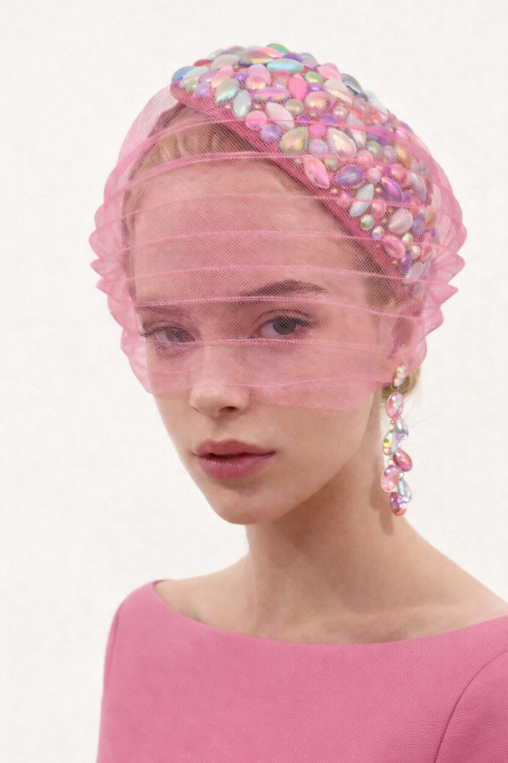 model wearing pink encrusted jewel headpiece with face veil