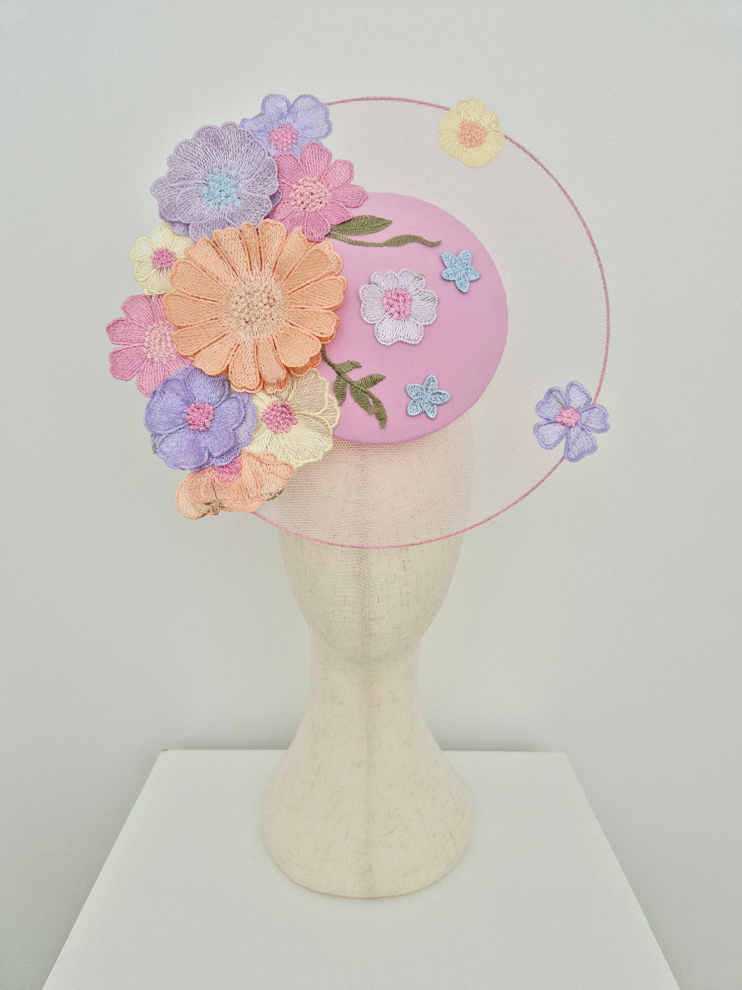 Pastel floral headband on a mannequin head against a white background