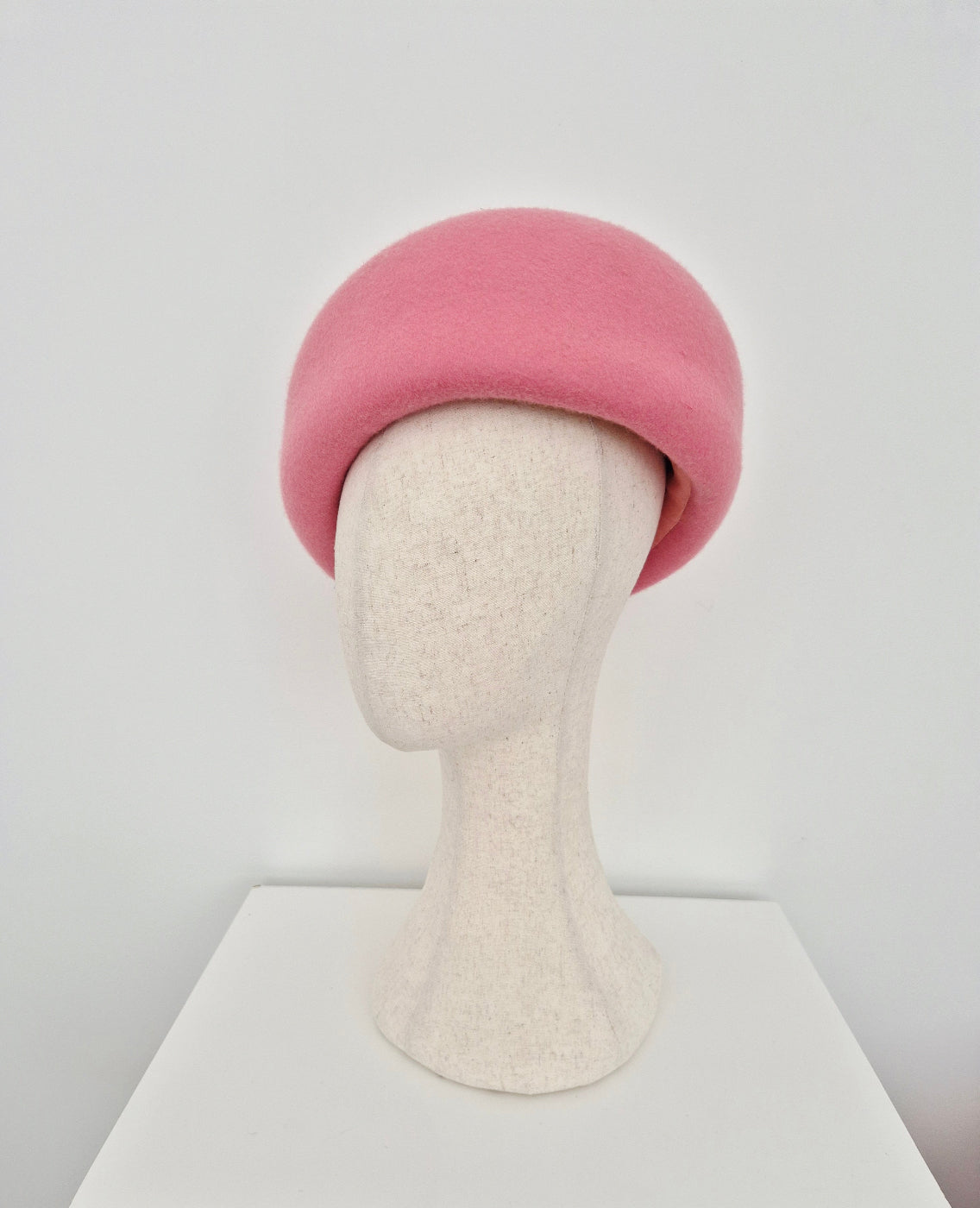 Pink oversized beret on a mannequin head against a white background side view