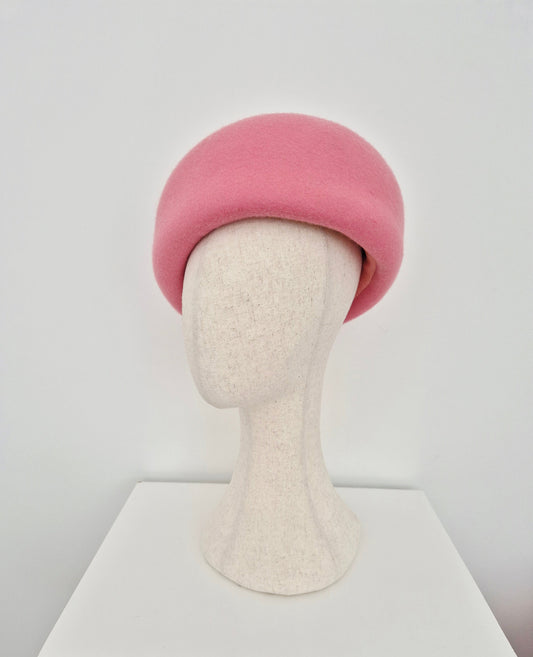 Pink oversized beret on a mannequin head against a white background side view