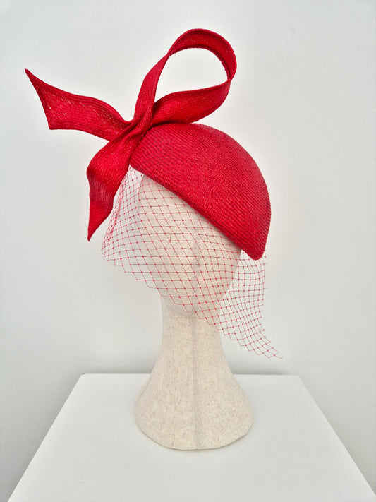 red beret style headpiece with veiling and bow