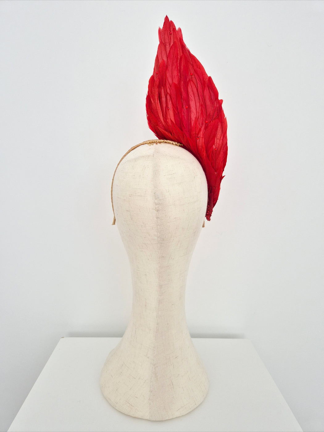 red feather headpiece back view on a manniquin head