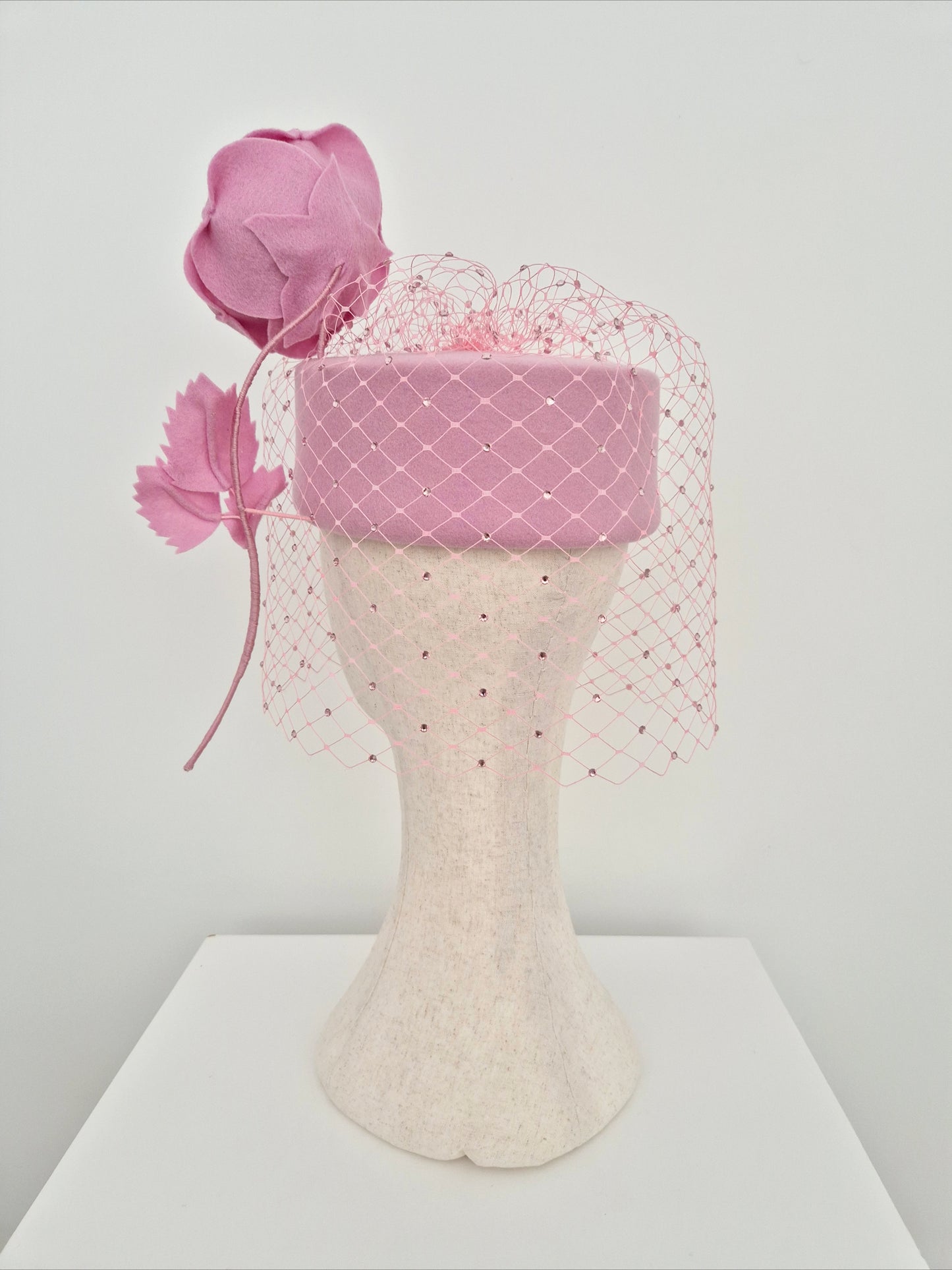 Miss Sabrina .Pink felt pillbox headpiece with rhinestone veiling and floating rose