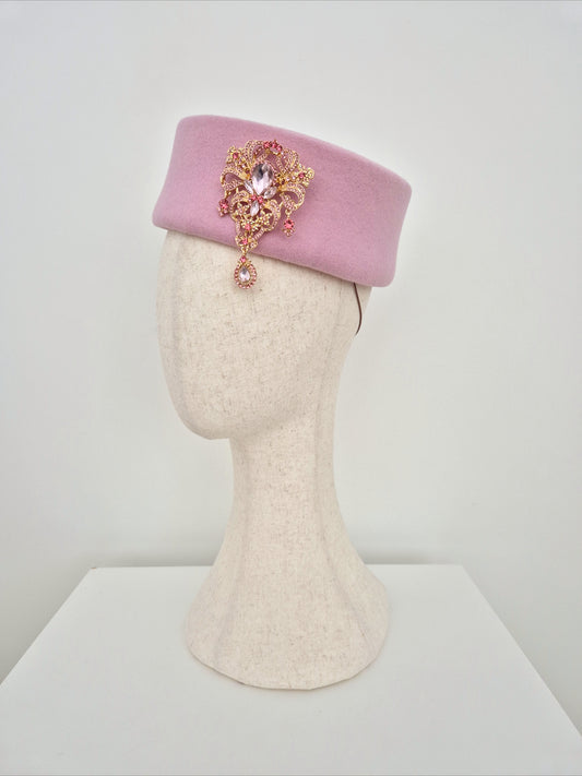 Miss Betty. Pink wool felt forward facing pillbox headpiece with rhinestone brooch