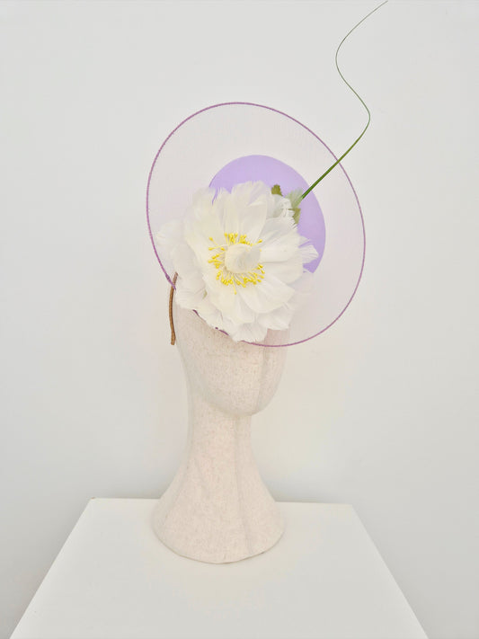 lilac satelitte percher headpiece with a ivory flower on a mannequin head with a white background side view