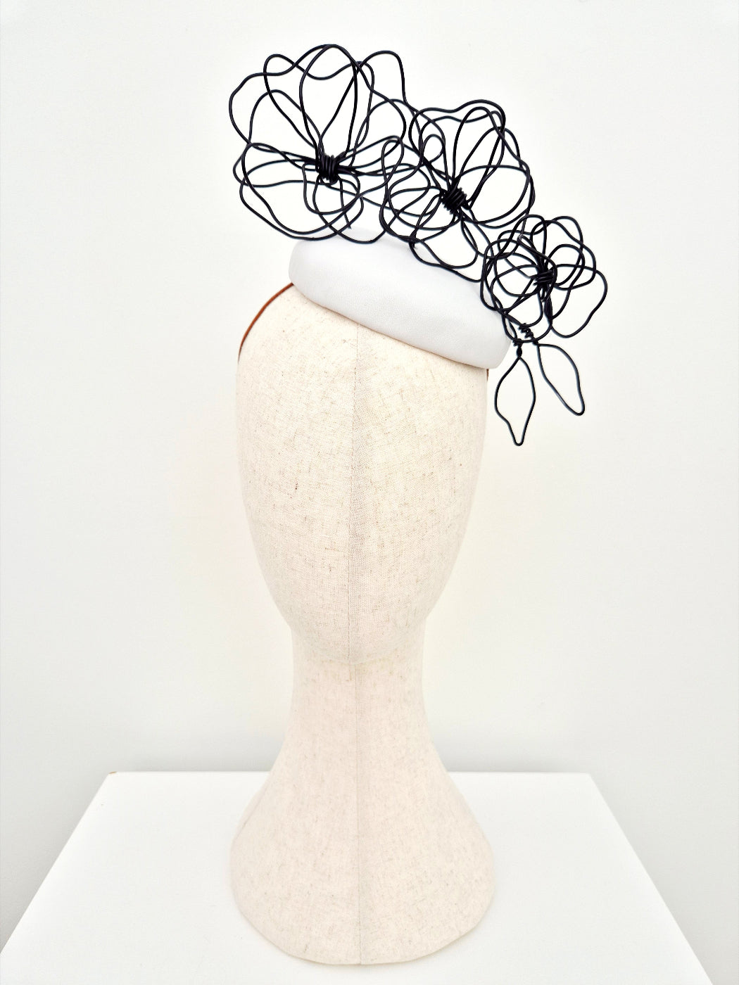 white button headpiece with black floral wirework