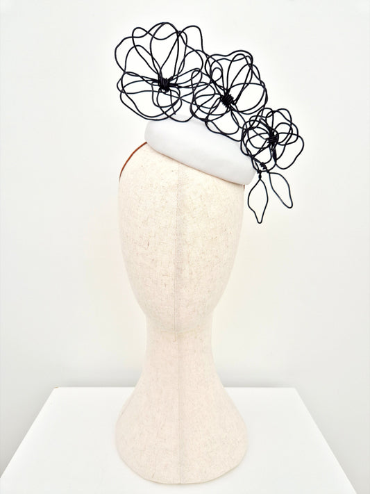 white button headpiece with black floral wirework
