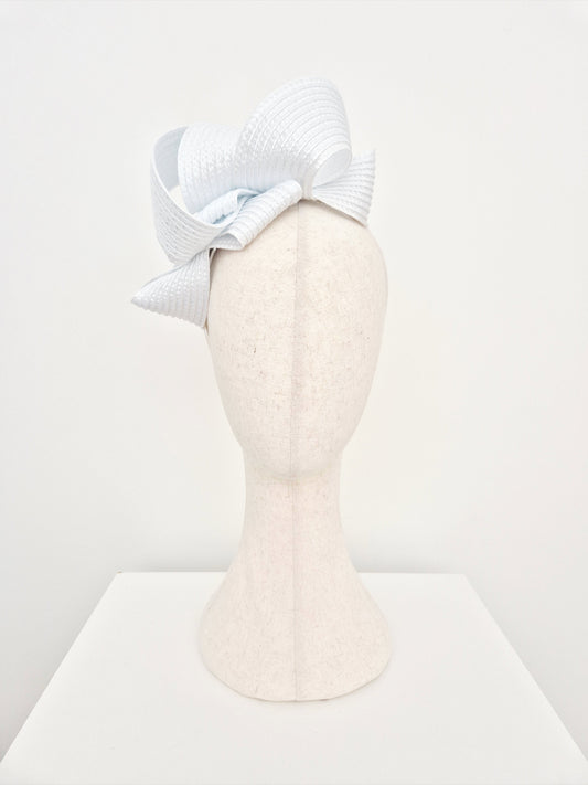 White  loop fascinator on a mannequin head against a white background
