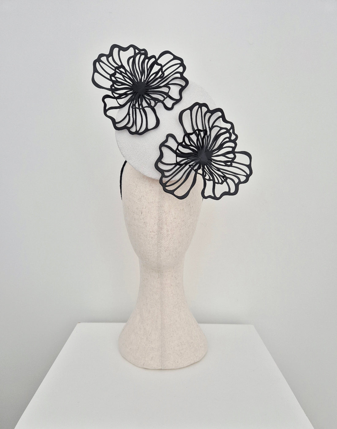 white percher headpiece with black flowers