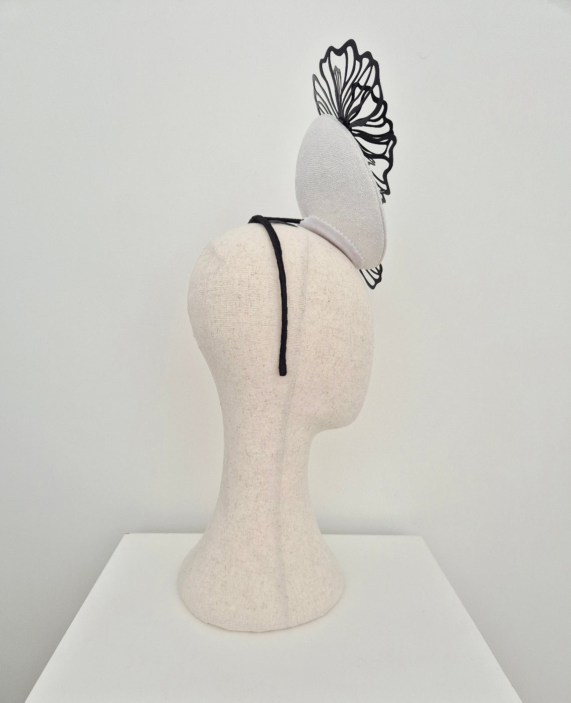 white percher headpiece with black flowers side view