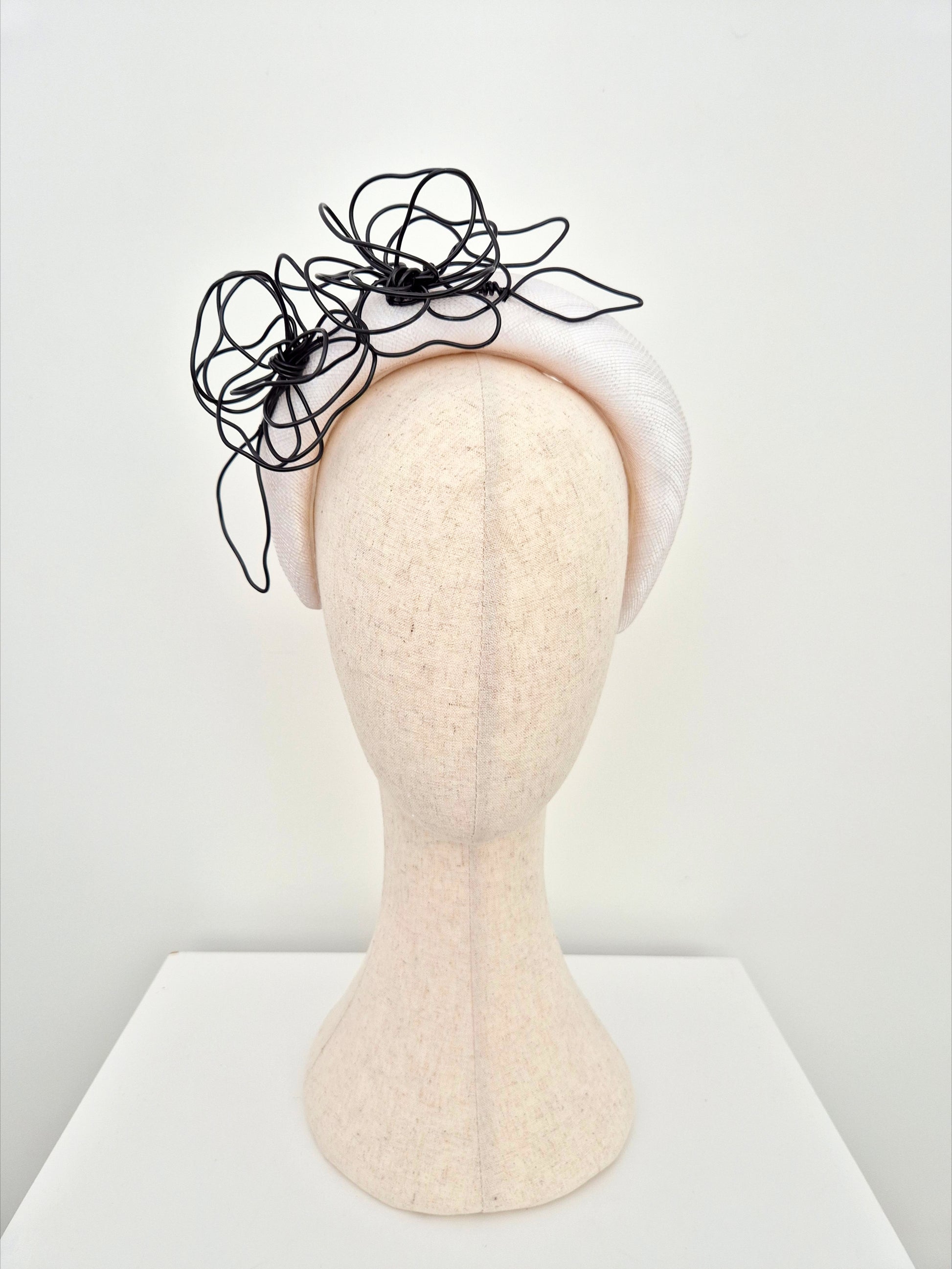 white straw padded headband with black floral wirework