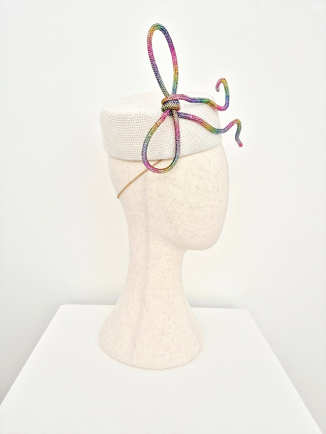 white straw pillbox headpiece with rhinestone bow side view